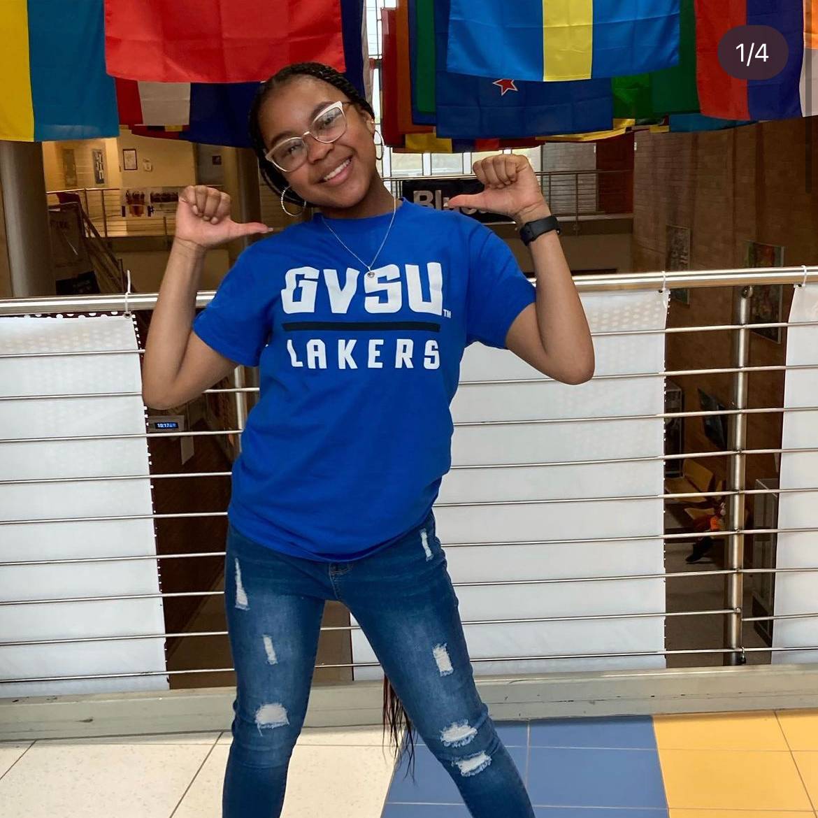 student wearing GVSU tshirt pointing to it with their thumbs